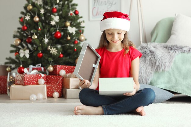 Petite fille avec des cadeaux de Noël à l'intérieur de Noël