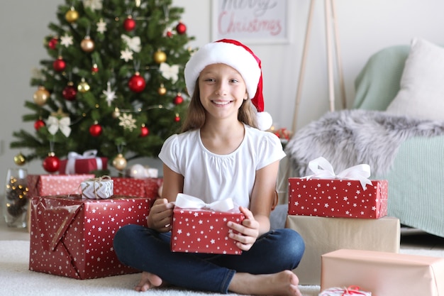 Petite fille avec des cadeaux de Noël à l'intérieur de Noël