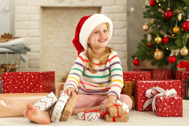 Petite fille avec des cadeaux de Noël à l'intérieur de Noël