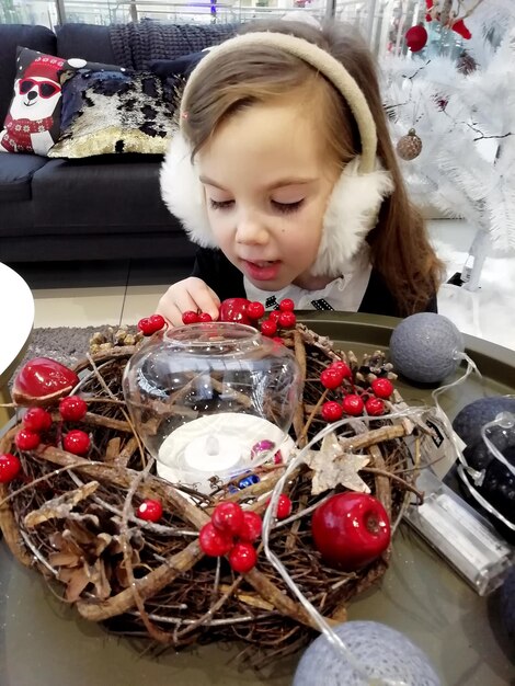 Photo une petite fille avec des cadeaux de noël près d'un arbre de noël à la maison