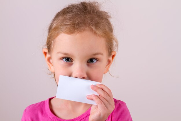 Petite fille avec une carte blanche isolée sur blanc