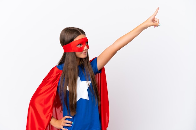 Petite fille caucasienne isolée sur fond blanc en costume de super-héros avec un geste fier