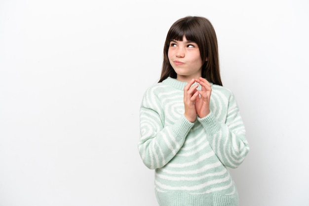 Petite fille caucasienne isolée sur fond blanc intrigant quelque chose