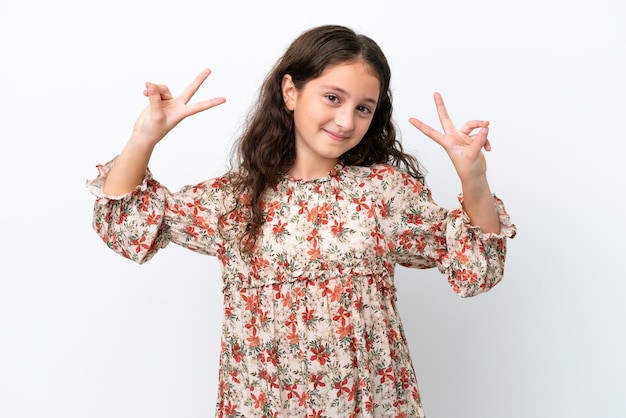 Petite fille caucasienne isolée sur fond blanc montrant le signe de la victoire avec les deux mains