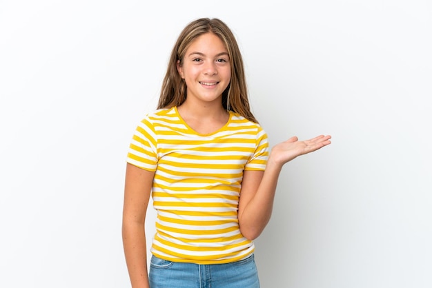 Petite fille caucasienne isolée sur fond blanc tenant un fond imaginaire sur la paume pour insérer une annonce