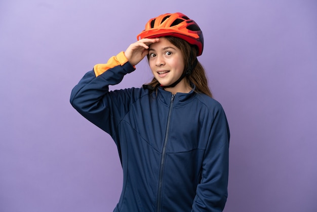 Petite fille caucasienne isolée sur fond violet faisant un geste surprise en regardant sur le côté