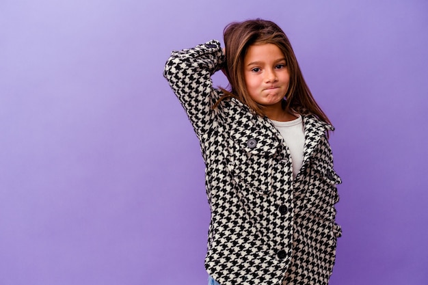 Petite fille caucasienne isolée sur fond violet Petite fille caucasienne isolée sur fond violet touchant l'arrière de la tête, pensant et faisant un choix.