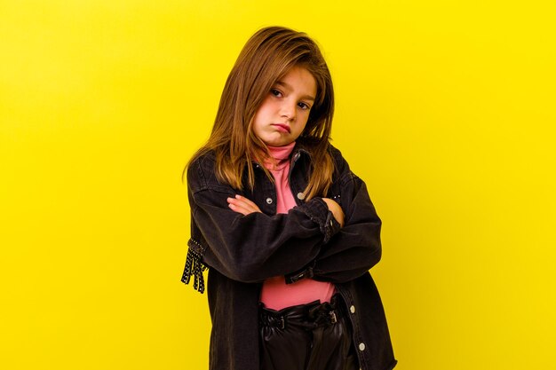 Petite fille caucasienne isolée sur jaune qui s'ennuie, fatiguée et a besoin d'une journée de détente.