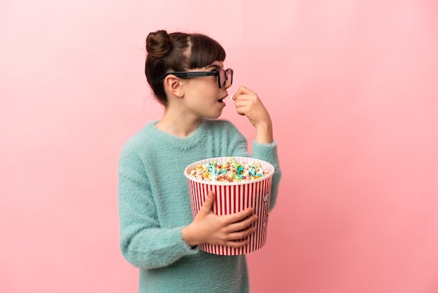 Petite fille caucasienne isolée avec des lunettes 3d et tenant un grand seau