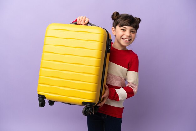 Petite fille caucasienne isolée en vacances avec valise de voyage