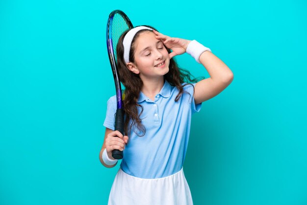 Une petite fille caucasienne jouant au tennis isolée sur fond bleu a réalisé quelque chose et a l'intention de trouver la solution