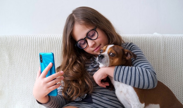 petite fille caucasienne mignonne dans des verres faire un téléphone selfie avec chien