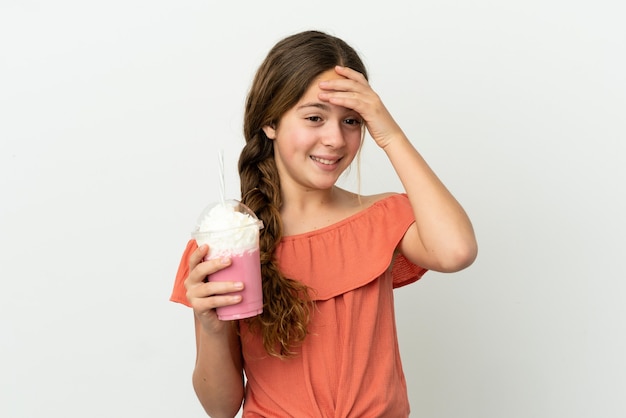 Petite fille caucasienne avec milk-shake aux fraises isolé sur fond blanc souriant beaucoup