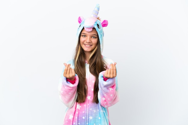 Petite fille caucasienne portant un pyjama licorne isolé sur fond blanc faisant un geste d'argent