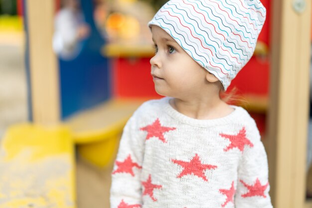 Petite fille caucasienne vêtue d'un chapeau et d'un pull