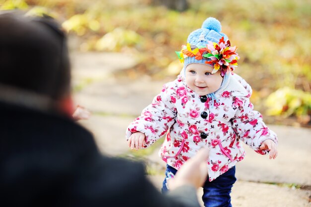 petite fille avec un cerceau coloré sur la tête sur un fond d&#39;arbres d&#39;automne