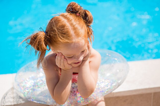 petite fille avec un cercle de natation dans la piscine