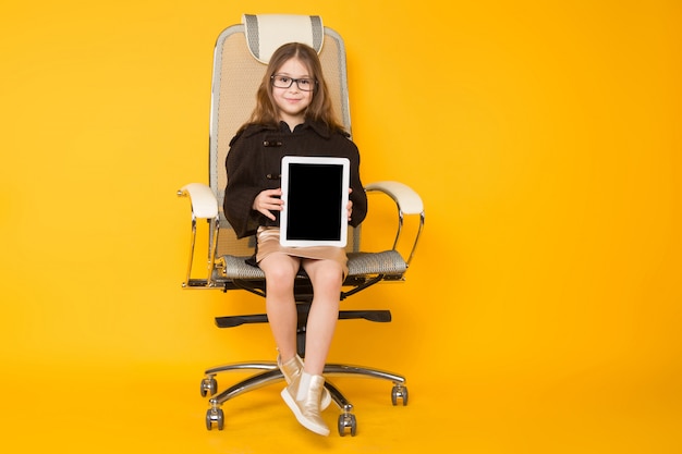 Petite fille en chaise avec tablette