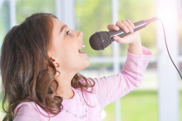 Petite fille chantant avec microphone