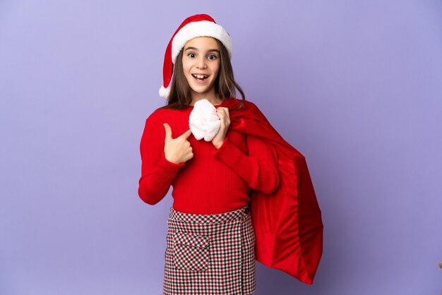 Petite fille avec chapeau et sac de Noël isolé