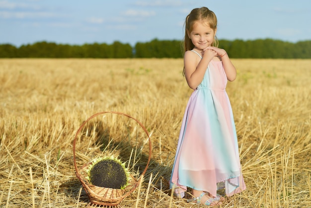 Petite fille charmante de cinq ans posant dans le champ