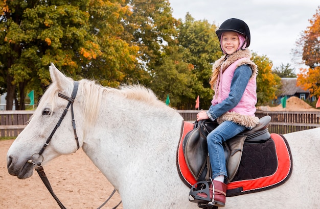 Petite fille à cheval dans une ferme