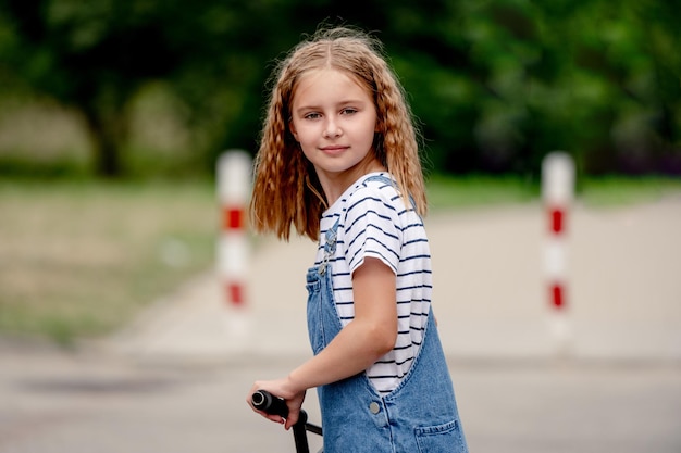 Petite fille chevauche une trottinette