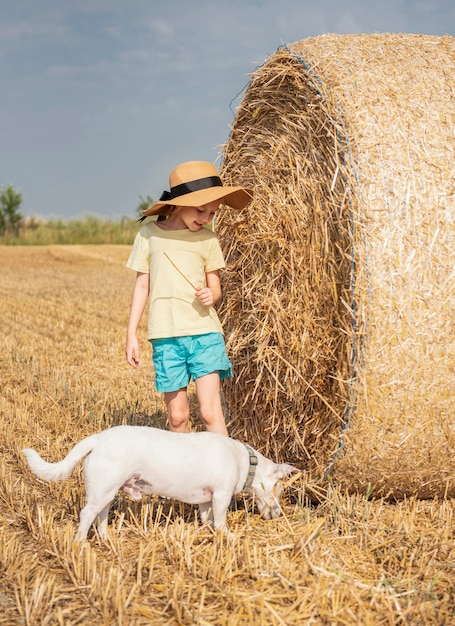 Petite fille et chien s'amusant dans un champ de blé un jour d'été