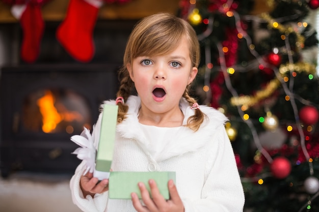 Petite fille choquée ouvrant un cadeau