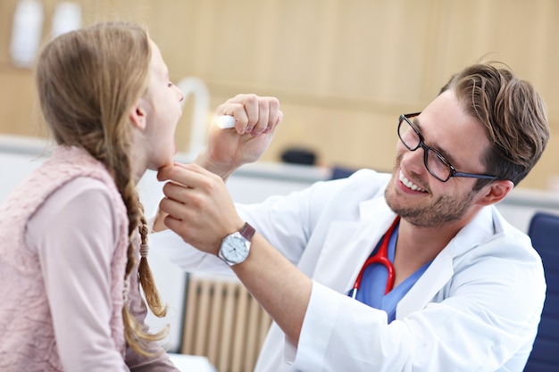 Petite fille en clinique examinée par un laryngologiste