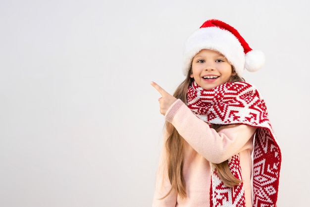 Une petite fille coiffée d'un chapeau du Nouvel An pointe du doigt la publicité.