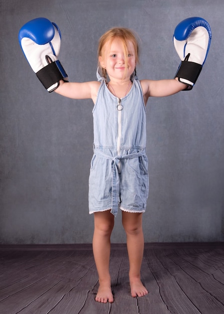 Petite fille comme un champion avec les mains en l'air. Concept d'enfants et de sport.