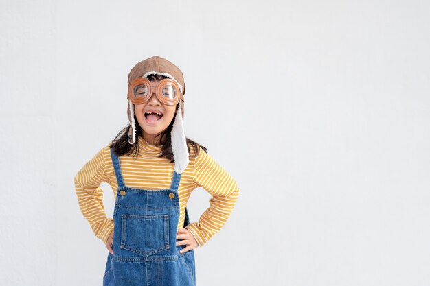 Une petite fille en costume d'astronaute joue et rêve de devenir astronaute. sur fond blanc