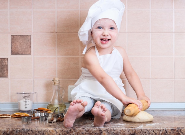 petite fille en costume de cuisinier