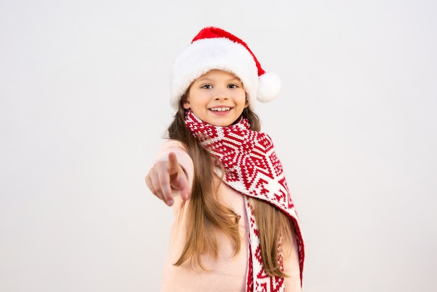 Une petite fille en costume du Nouvel An pointe son doigt vers l'avant.