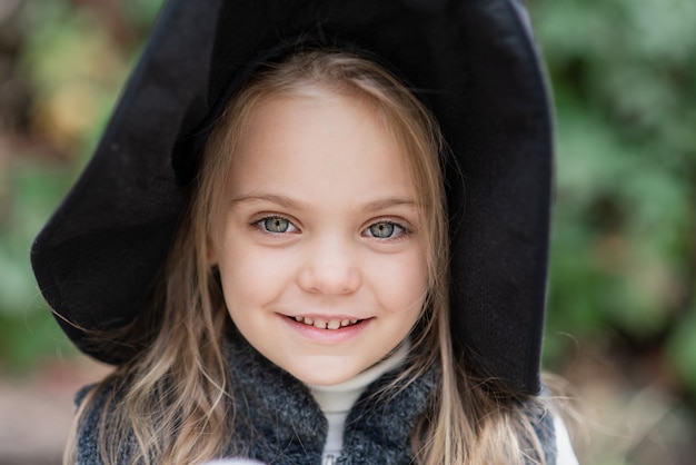 Petite fille en costume whitch célèbre Halloween en plein air