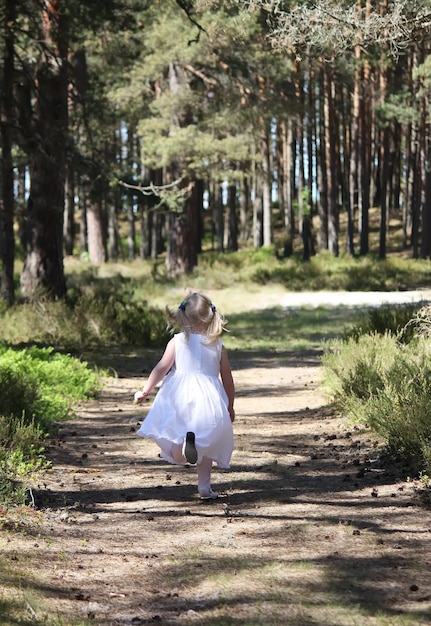 Petite fille courant au soleil dans le parc d'automne