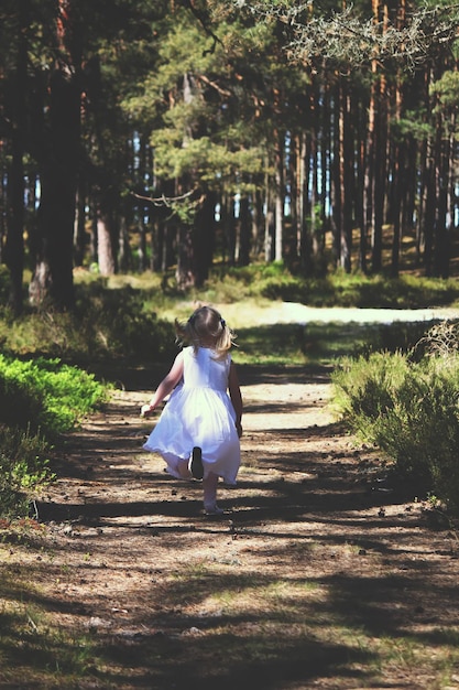 Petite fille courant au soleil dans le parc d'automne