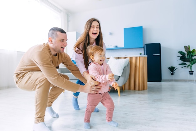 Une petite fille court dans la pièce, des parents heureux courent