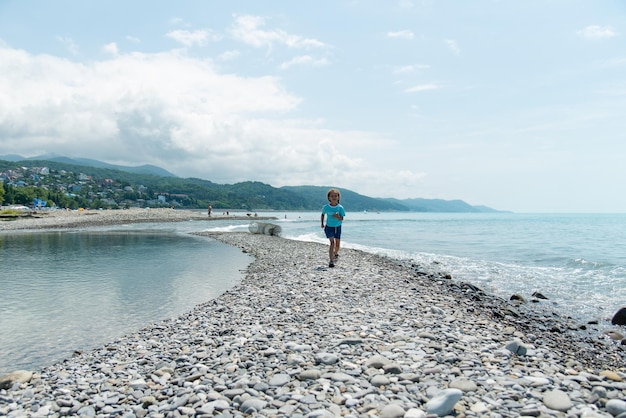 Une petite fille court le long de la plage Été