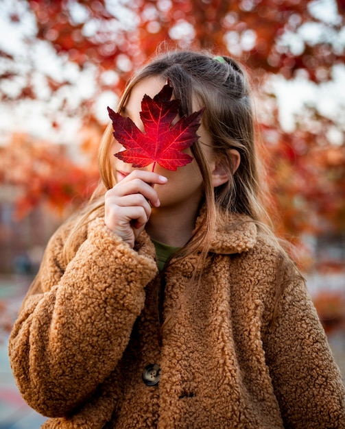 Photo petite fille couvrant son visage avec une feuille