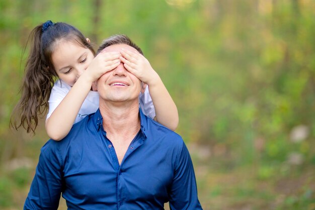 Petite fille couvrant les yeux de son père