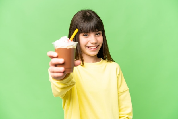 Petite fille avec de la crème au chocolat sur fond isolé chroma key avec une expression heureuse