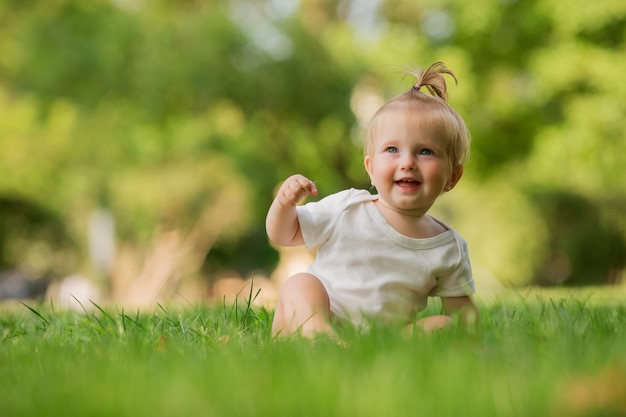 petite fille dans un bac à sable blanc sur l'herbe verte