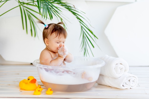 Photo petite fille dans un bassin avec de la mousse et de l'eau