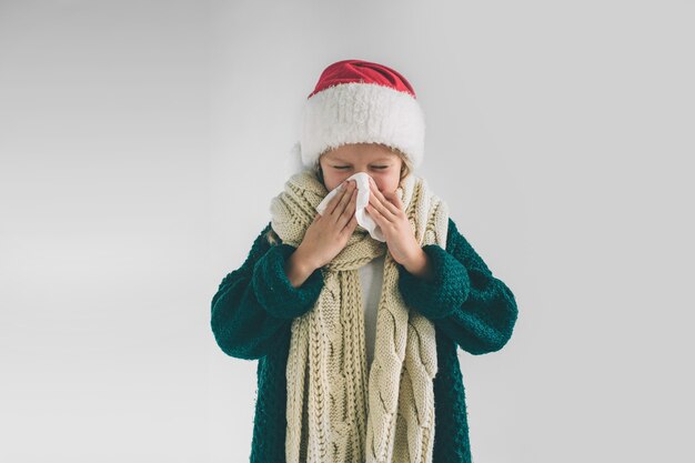 Petite fille dans un chapeau de Noël sur fond blanc