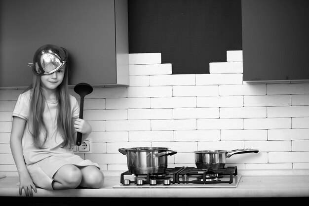 Petite fille dans la cuisine avec équipement de cuisine