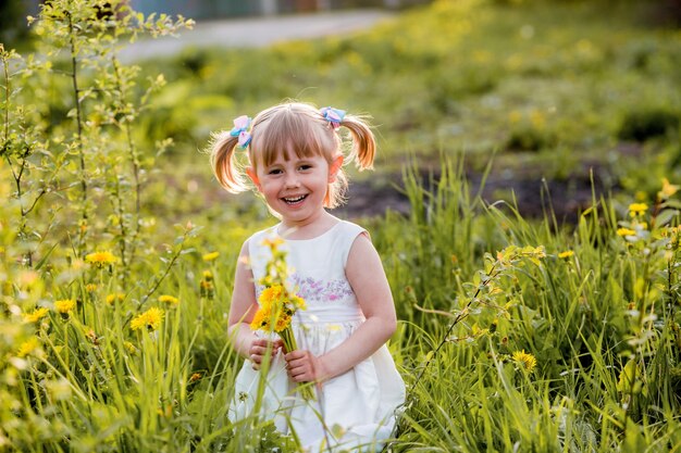 Petite fille dans le domaine des pissenlits