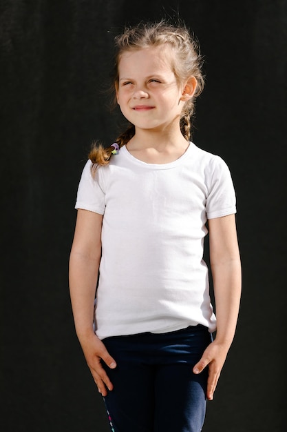 Petite fille dans l'espace de t-shirt blanc pour votre logo ou maquette de conception à imprimer