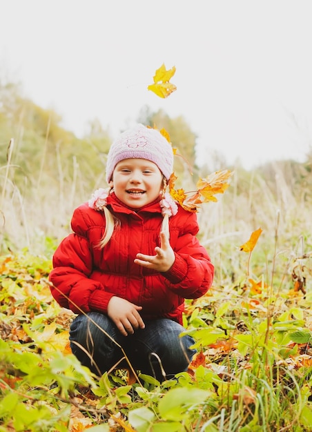 Petite fille dans la forêt d'automne Enfant avec des feuilles d'érable